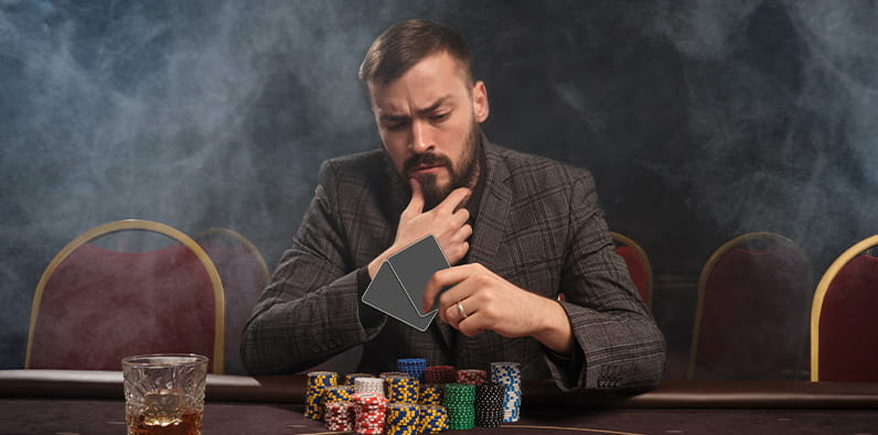 Jogador de casino concentrado sentado à mesa de casino
