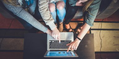 Grupo de pessoas a apontar para o computador