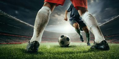 Dois atletas a jogar futebol