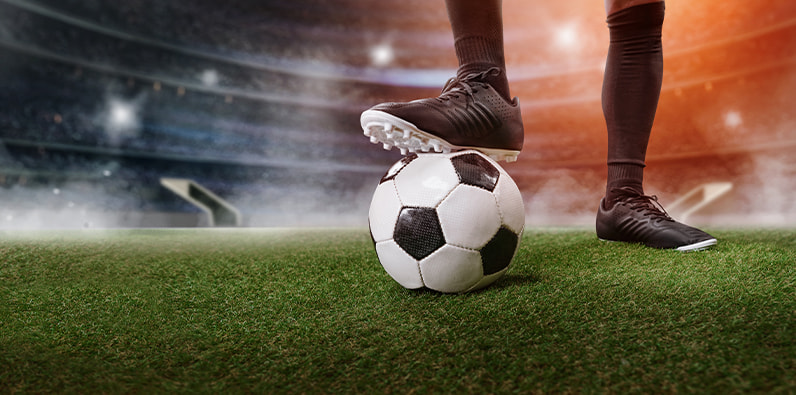 Jogador a pisar uma bola de futebol